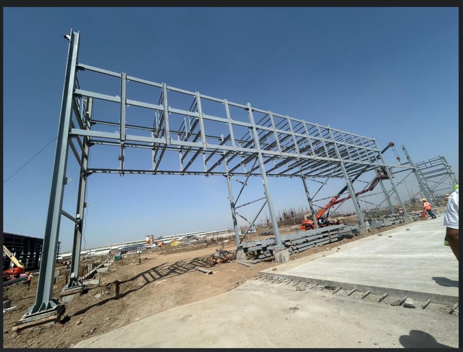 Structural steel portal frame being erected at an outdoor construction site